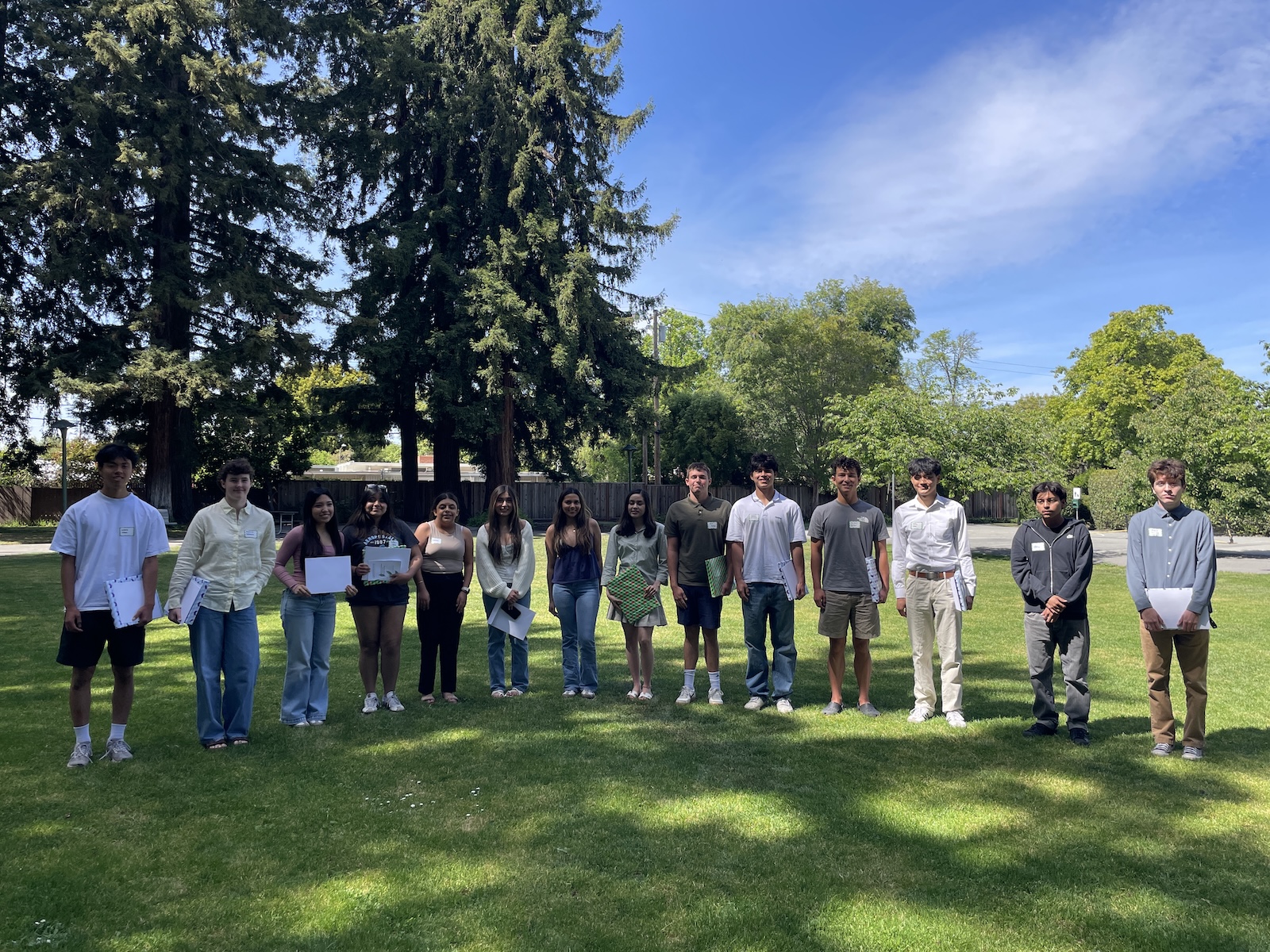 The 2026 finalists standing together on the lawn at Greenmeadow Park, holding the books and certificates they received.